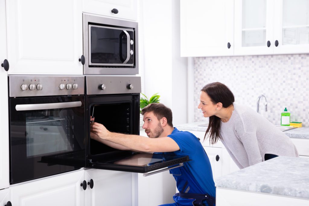 Technician diagnosing an oven